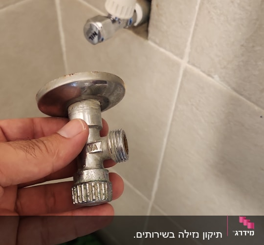 ברז וצינור מים על קיר אריחים